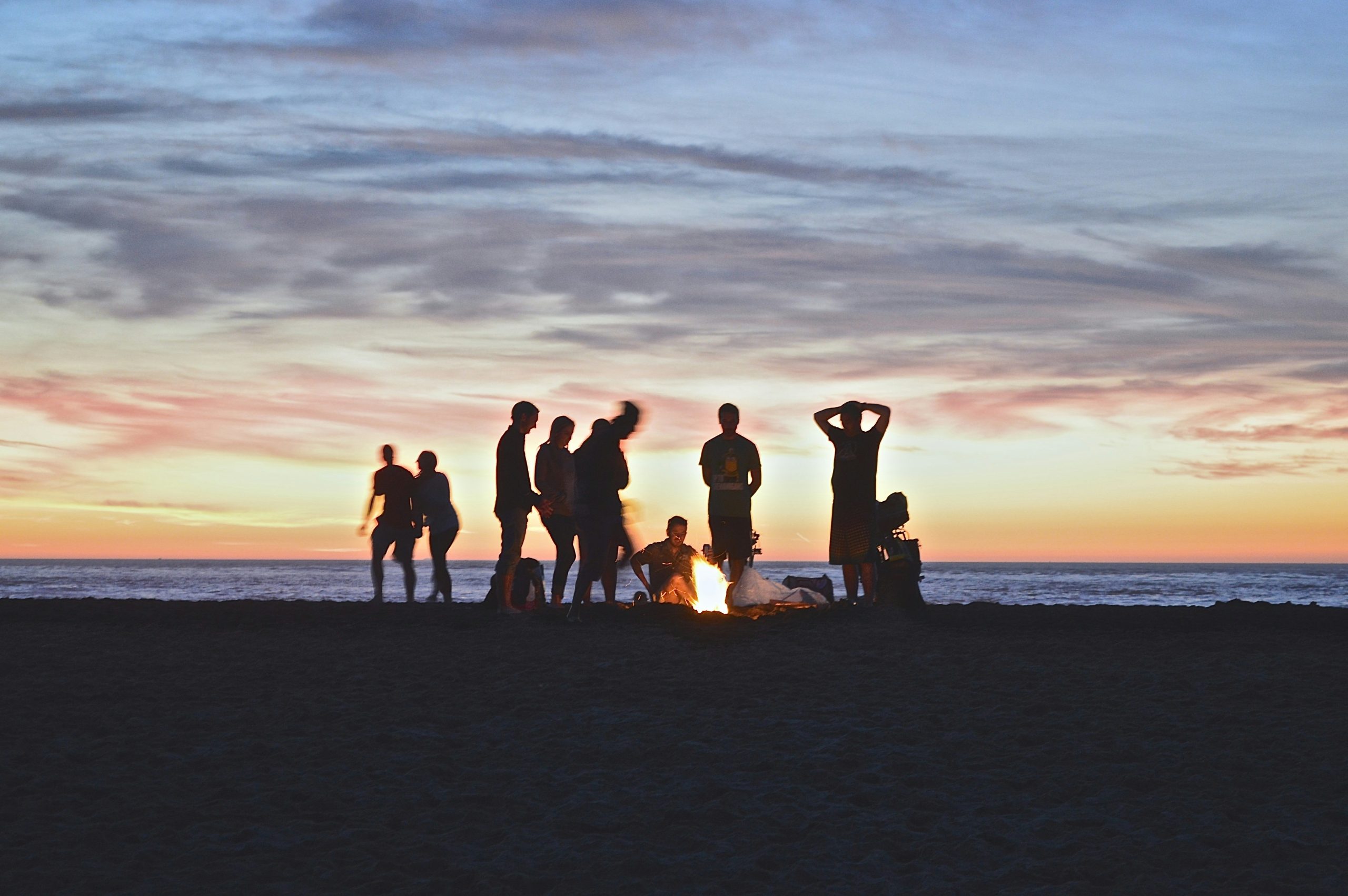 Groupe de jeunes autour d’un feu de camp au coucher du soleil, lors d’une expérience immersive organisée par TUAAP